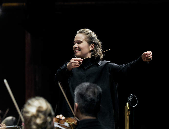 Photo zoomée sur la cheffe Eva Ollikainen en pleine direction de la Symphonie N° 6 de Mahler, lors du concert du 10 décembre avec l'Orchestre de la Suisse Romande et la cheffe Eva Ollikainen